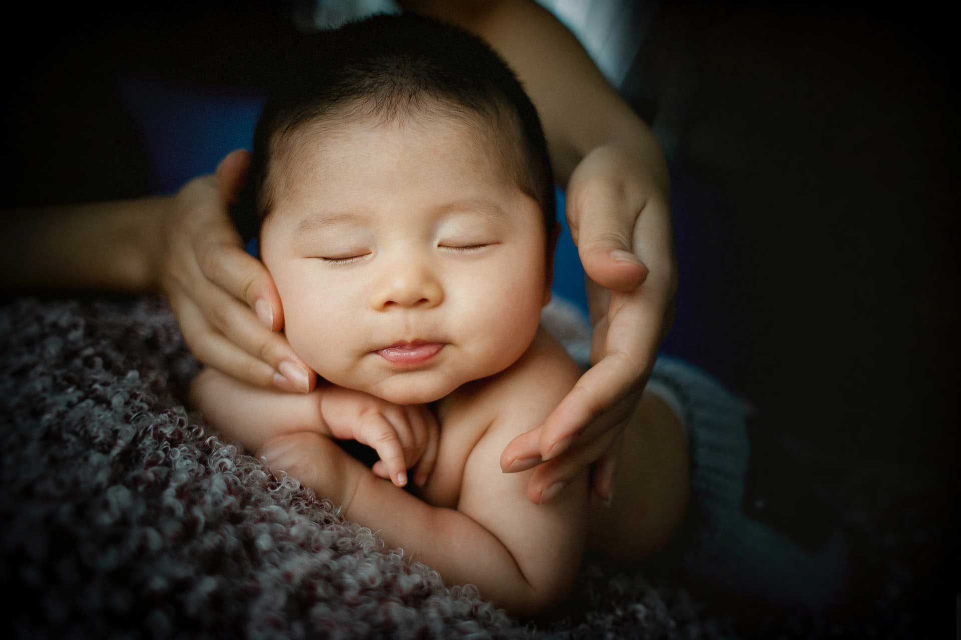 Hands gentyly supporting a baby's head